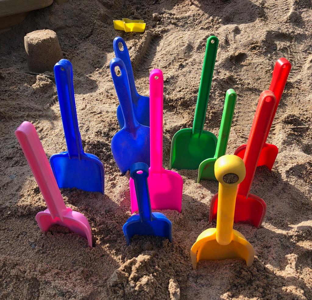 lasten leikkilapioita pystyssä hiekkalaatikossa